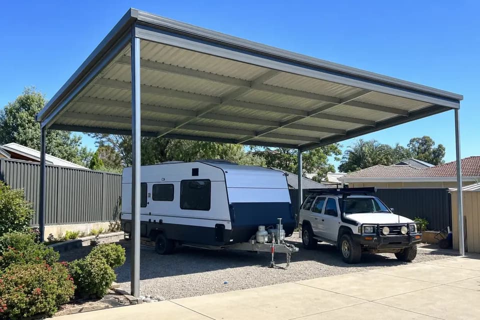 Extra-high steel carport over a caravan and a 4WD in a Perth side yard