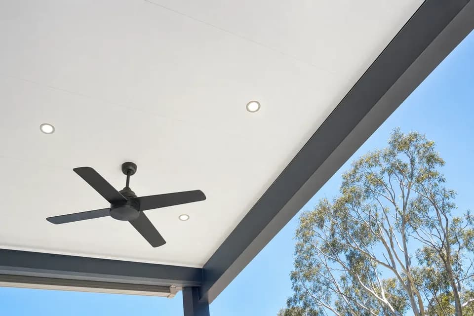 Smooth white insulated patio ceiling with three downlights and a black ceiling fan