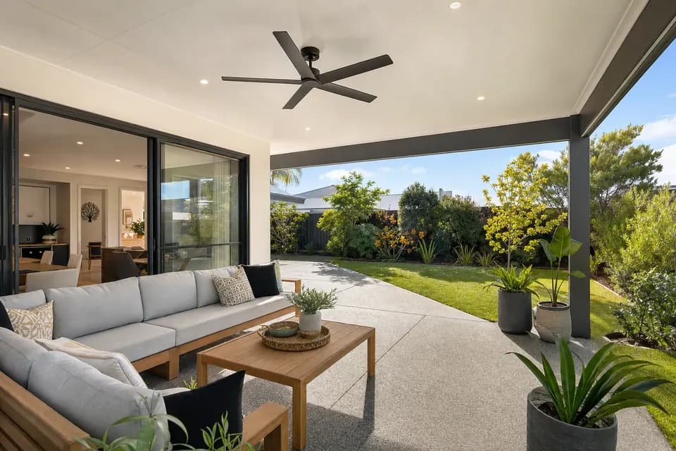 Insulated patio ceiling with downlights and a ceiling fan over an outdoor lounge beside glass sliding doors