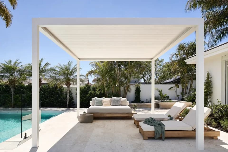 White louvre roof patio with blades closed over a daybed beside a Perth backyard pool