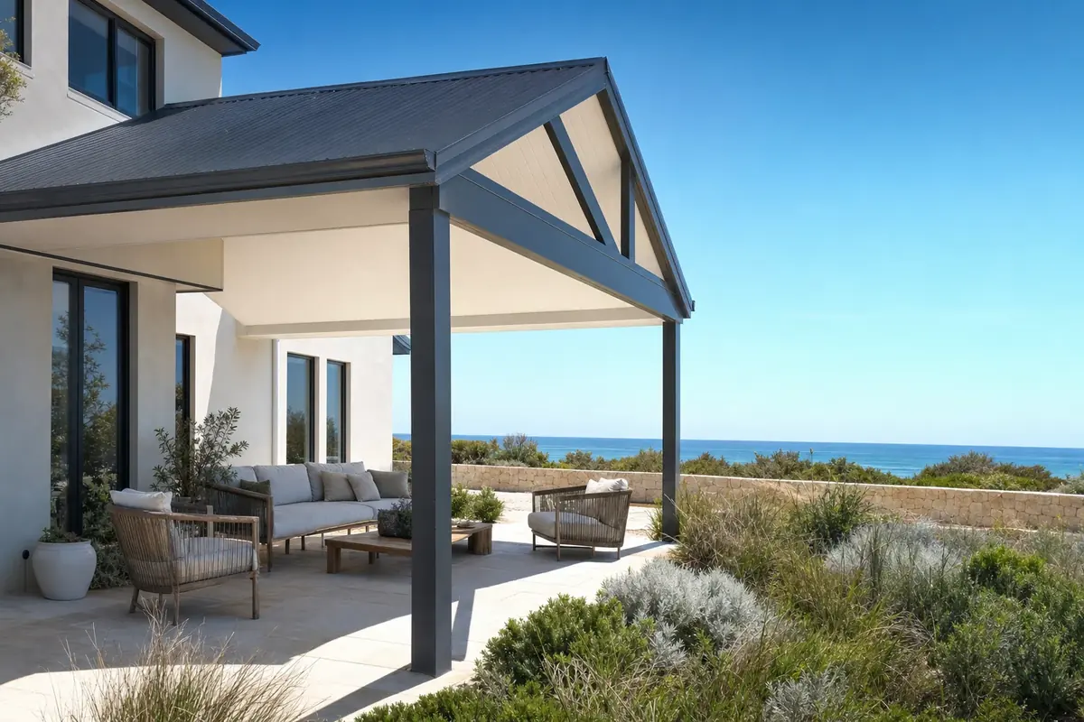 Charcoal gable patio with an open steel truss over an outdoor lounge at a coastal home with an ocean view
