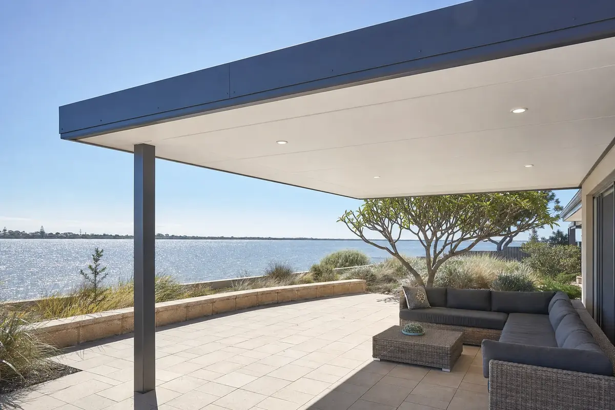 Insulated flat roof patio with downlights over an outdoor lounge at a coastal home