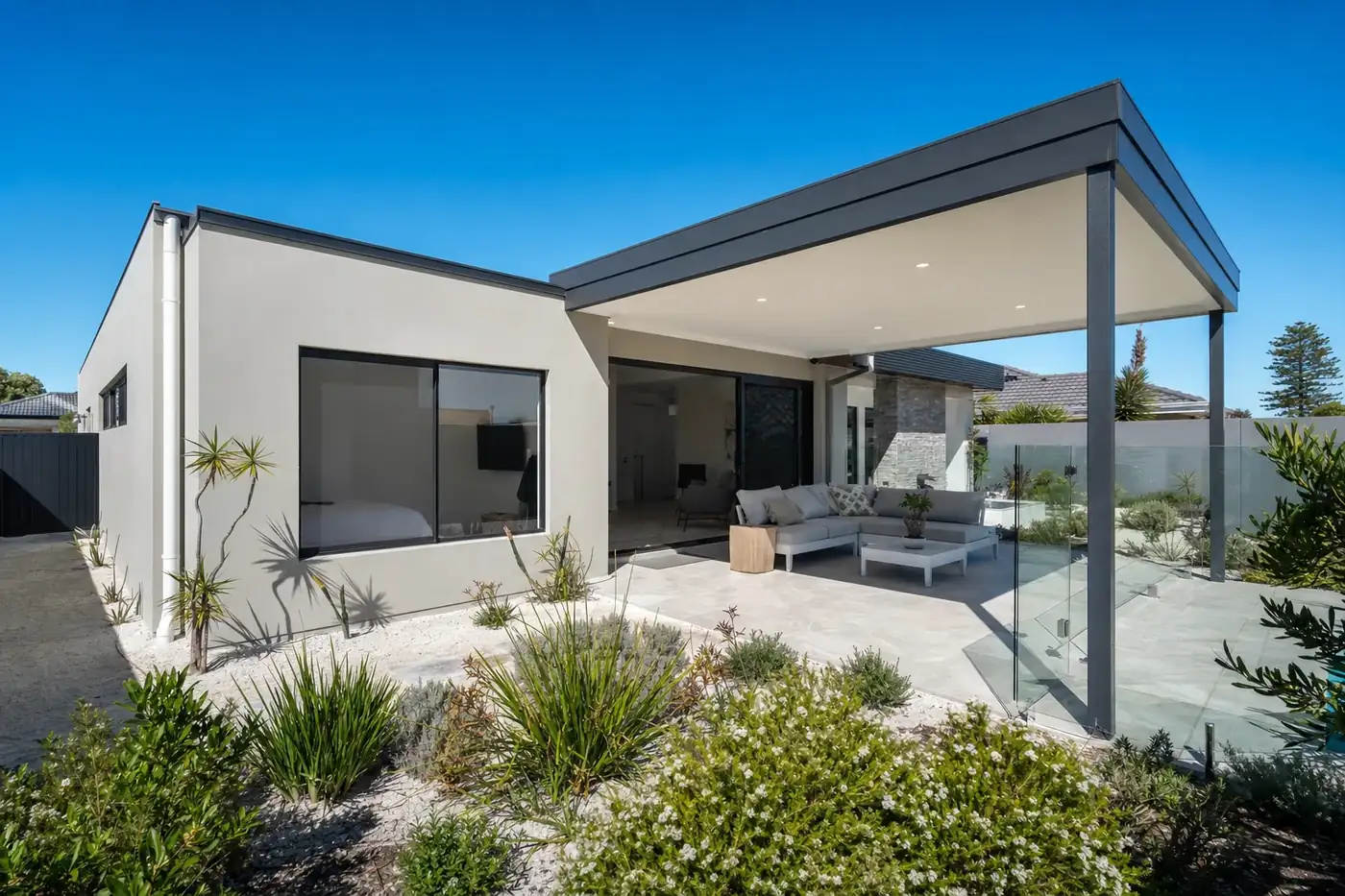 Dark grey flat roof patio over a tiled alfresco and outdoor lounge at a modern rendered home