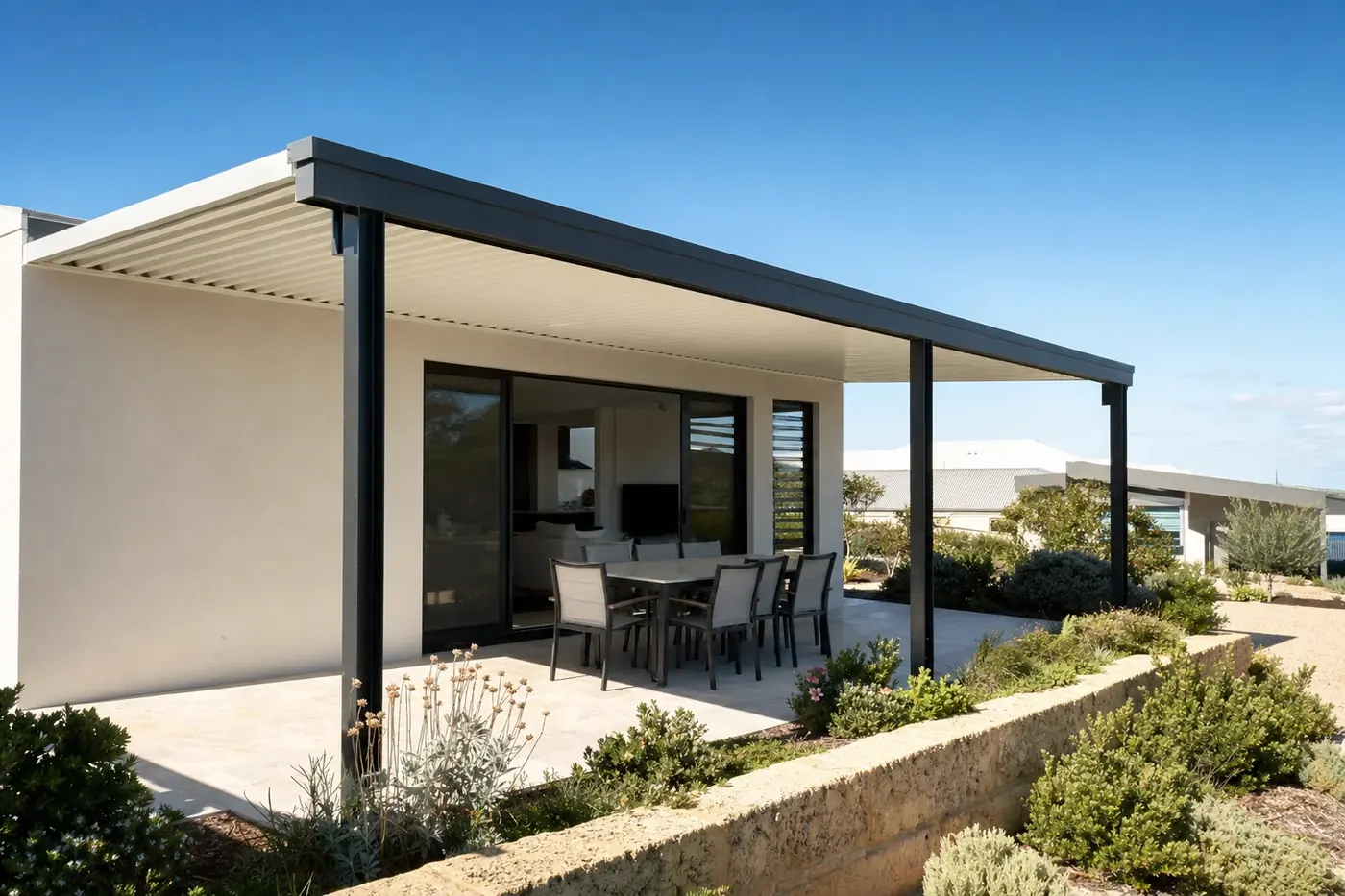 Charcoal and white steel patio over a limestone-paved alfresco at a new rendered home in Yanchep
